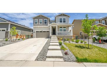 Charming two-story home featuring a welcoming porch and landscaped front yard with a concrete staircase at 3888 Grand Baker St, Aurora, CO 80019