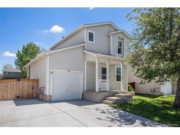 Charming two-story home with a well-maintained front yard, driveway, and attached one-car garage on a sunny day at 1232 Bluebird St, Brighton, CO 80601