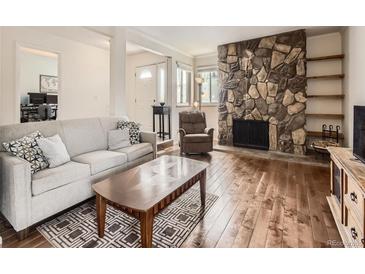 Cozy living room features a stone fireplace, hardwood floors, and comfortable seating at 13645 E Yale Ave # C, Aurora, CO 80014