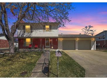 Charming two-story home with a brick facade, landscaped yard, and a spacious two-car garage at 1941 E 119Th Pl, Northglenn, CO 80233