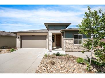 Charming single-Gathering home boasts a two-car garage, stone accents, and a well-maintained landscaped front yard at 10786 Bear Cub Dr, Broomfield, CO 80021