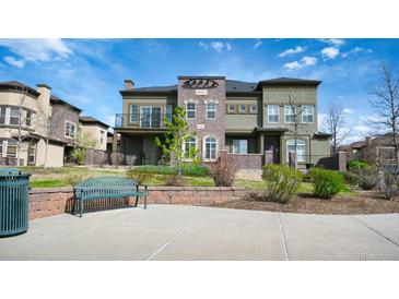 Inviting home featuring a landscaped lawn, charming brick accents, and a cozy front patio with comfortable seating at 924 Brookhurst Ave # C, Highlands Ranch, CO 80129