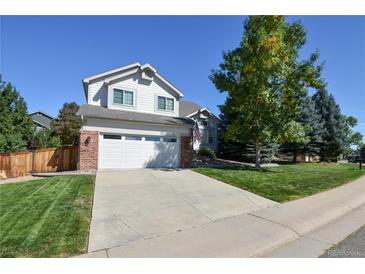 Charming two-story home features a manicured front yard, attached garage, and classic architectural details at 7641 Lebrun Ct, Lone Tree, CO 80124