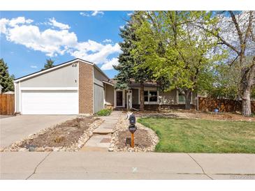 Charming home with a well-maintained front yard, mature trees, and stone pathway leading to the entrance at 4650 S Laredo St, Aurora, CO 80015