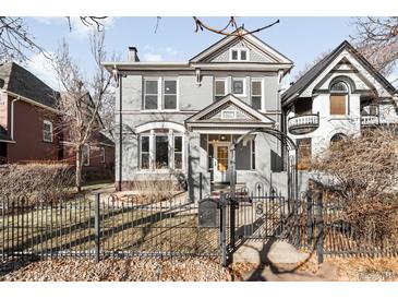 Charming gray two-story home featuring a well-kept front yard and decorative black iron fence at 2823 N Lafayette St, Denver, CO 80205