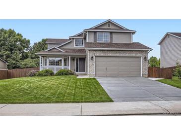 Traditional two-story home boasts a two-car garage and manicured front lawn at 1641 Cedarwood Dr, Longmont, CO 80504