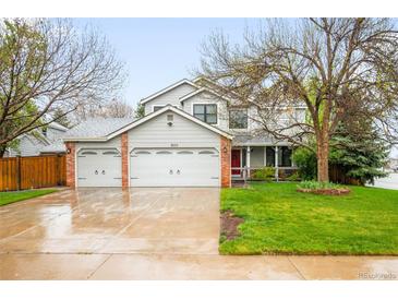 Charming two-story home featuring a three-car garage, landscaped yard, and inviting front porch at 8523 S Flower Ct, Littleton, CO 80128
