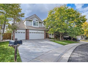 Charming two-story home with a three-car garage, brick accents, a large yard, and mature trees at 13723 Milwaukee Ct, Thornton, CO 80602