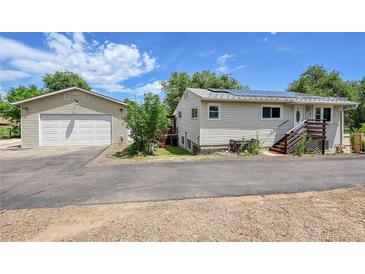Charming home with a detached garage and a spacious driveway, solar panels and a cozy front entrance at 3145 S Bryant St, Englewood, CO 80110