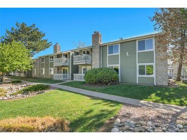 Inviting exterior of the building with stone accents, green siding, and well-maintained landscaping at 4400 S Quebec St # 207L, Denver, CO 80237