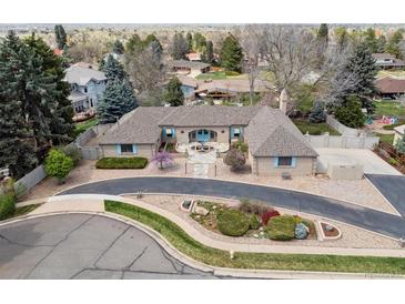 Sprawling single story home with circular driveway, lush landscaping, and mountain views at 2653 S Harrington Ln, Lakewood, CO 80227