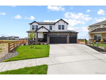 Beautiful two-story home boasting a three-car garage, stone accents, and a manicured lawn at 16002 E 111Th Cir, Commerce City, CO 80022