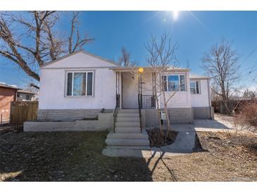 Charming single-story home with white stucco and stone accents, inviting curb appeal, and a well-maintained front yard at 3500 W 55Th Ave, Denver, CO 80221