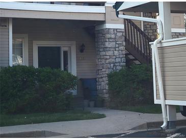 A charming home exterior featuring a stone pillar and lush green landscaping at 4054 S Carson St # 102, Aurora, CO 80014