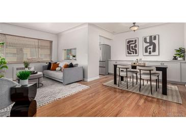 Bright living room featuring hardwood floors, modern furniture, neutral paint, and stainless steel appliances at 1454 Jersey St # 104, Denver, CO 80220