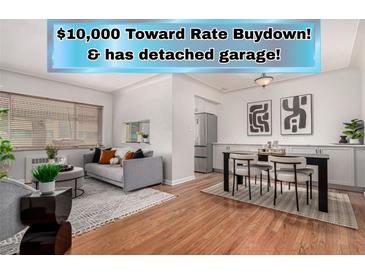 Bright living room with hardwood floors, a gray sofa, and access to dining area with stainless steel appliances at 1454 Jersey St # 104, Denver, CO 80220