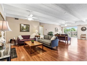Spacious living room features hardwood floors, large windows, and ample seating at 7877 E Mississippi Ave # 208, Denver, CO 80247