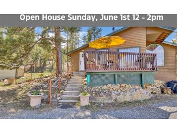 Charming cabin with a wooden deck, stone accents, and inviting steps leading to the front entrance at 11798 Ridge Rd, Golden, CO 80403
