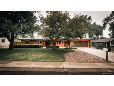 Charming single-story brick home with a well-maintained lawn, mature trees, and an attached garage at 11673 W 28Th Ave, Lakewood, CO 80215