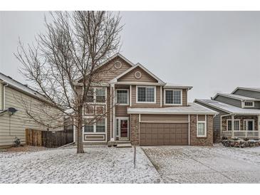 Charming two-story home with a well-maintained lawn and attached garage and beautiful snow covered front yard at 560 Hampstead Ave, Castle Rock, CO 80104