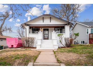 Charming home with white exterior, gray trim, landscaped yard and front yard sidewalk leading to the entrance at 2933 Benton St, Wheat Ridge, CO 80214