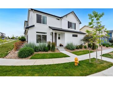 Charming two-story home featuring a well-manicured lawn and tasteful landscaping at 10254 Worchester St, Commerce City, CO 80022