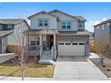 Charming two-story home featuring stone accents, a two-car garage, and a welcoming front porch at 24432 E Tennessee Pl, Aurora, CO 80018