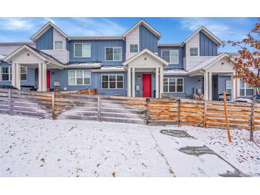 Charming townhome with a blue exterior, white trim, a red door, and a quaint wooden fence at 6211 W 28Th Ct, Wheat Ridge, CO 80214