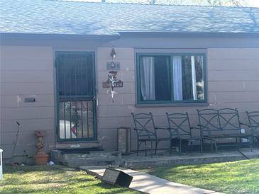 A single-story home has a secure door and seating area on the front porch at 1840 W Arkansas Ave, Denver, CO 80223
