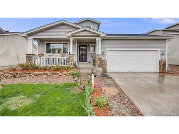 Charming home with a welcoming porch, stone accents, lovely landscaping and a well-maintained lawn at 9674 Fox Den Dr, Littleton, CO 80125