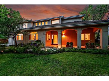 Stunning home exterior featuring an arched porch, manicured lawn, and vibrant landscaping at 2558 Premier Pl, Boulder, CO 80304