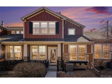 Beautiful townhome featuring stone accents, neutral-colored siding, black shutters, and a well-manicured front yard at 3751 W 136Th Ave # S3, Broomfield, CO 80023