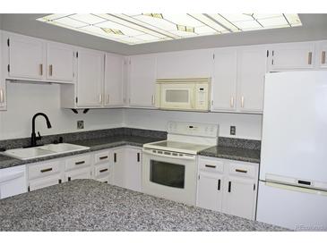 Bright kitchen features white cabinets, granite countertops, and modern appliances at 13952 E Marina Dr # 304, Aurora, CO 80014