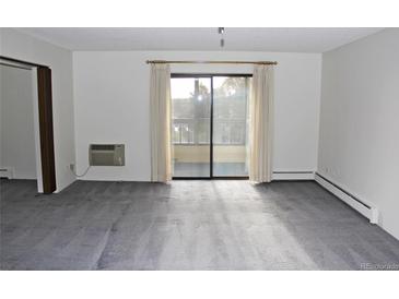 Bright living room with balcony access and carpet flooring at 13952 E Marina Dr # 304, Aurora, CO 80014