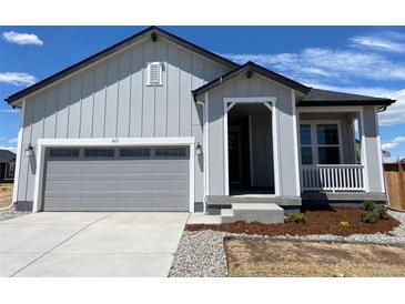 Charming single-Gathering home with a grey exterior, attached garage, and a cozy front porch with white railings at 1613 Bloom St, Brighton, CO 80601