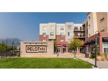 The Peloton apartments feature modern architecture, landscaping, and signage on a sunny day at 3701 Arapahoe Ave # 318, Boulder, CO 80303