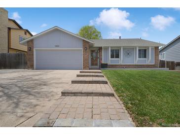 Charming single Gathering home with brick accents, well-manicured lawn, and inviting walkway at 18714 E Utah Cir, Aurora, CO 80017
