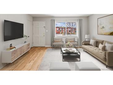 Bright living room with hardwood floors, large windows, and modern furnishings at 12893 W Alameda Dr, Lakewood, CO 80228