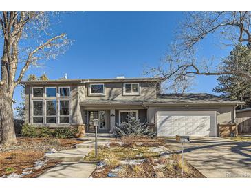 Two-story house with a white garage door and landscaped yard at 5760 S Geneva St, Greenwood Village, CO 80111