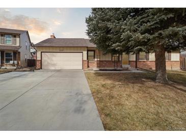 Brick ranch home with attached garage and mature landscaping at 15037 E Carolina Pl, Aurora, CO 80012