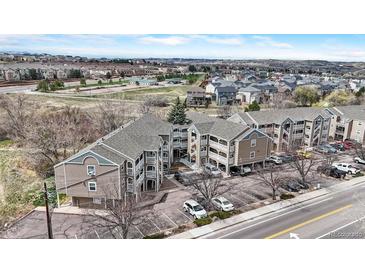 A building with multiple levels and balconies overlooks a road with mountains in the distance at 1263 S Gilbert St, Castle Rock, CO 80104