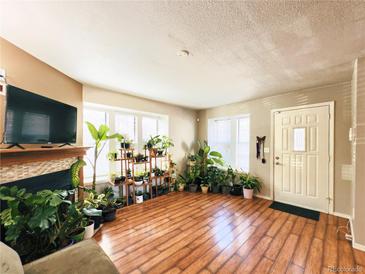 Inviting living room featuring a fireplace, natural light, and beautiful flooring at 1120 S Waco St # A, Aurora, CO 80017