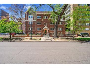 Brick apartment building with mature trees and landscaping is located in the city at 963 N Logan St # 2, Denver, CO 80203