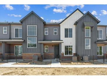 Modern townhome featuring large windows and neutral gray and white siding at 6902 Huddersfield Ln, Castle Pines, CO 80108