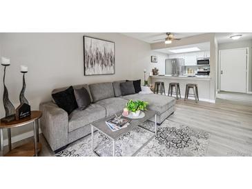 Comfortable living room features a large gray couch, modern decor, and an open view to the kitchen at 4274 S Salida Way # 6, Aurora, CO 80013