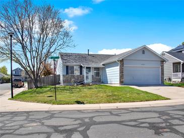 Charming single-story home with blue siding, stone accents, and well-manicured front yard at 5280 E 128Th Way, Thornton, CO 80241