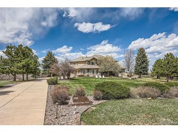 Beautiful home featuring lush landscaping, mature trees, and a circular driveway at 1289 Diamond Ridge Cir, Castle Rock, CO 80108