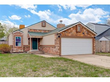 Charming single-Gathering home with brick accents, a green front door, and a two-car garage at 11420 E 1St Ave, Aurora, CO 80010