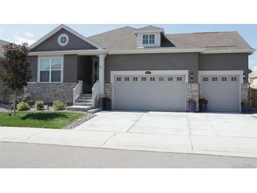 Charming single-Gathering home with a three car garage, stone accents, landscaped front yard and a covered front porch at 8371 S Cody Way, Littleton, CO 80128