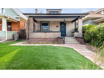 Charming brick home featuring a well-manicured lawn and covered front porch at 3445 N Clay St, Denver, CO 80211